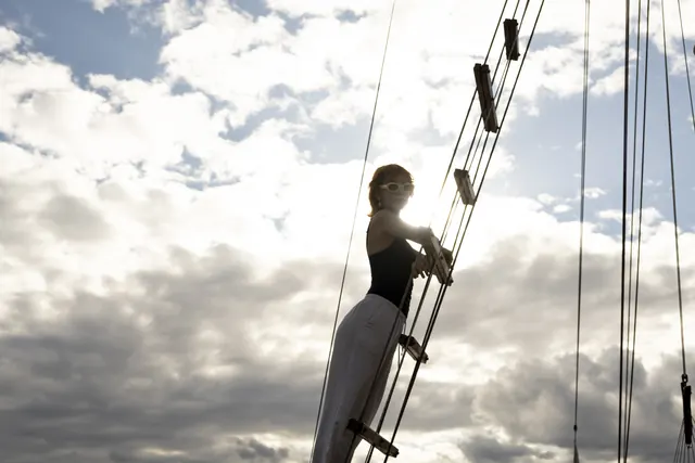 Guest standing beside the yacht rigging